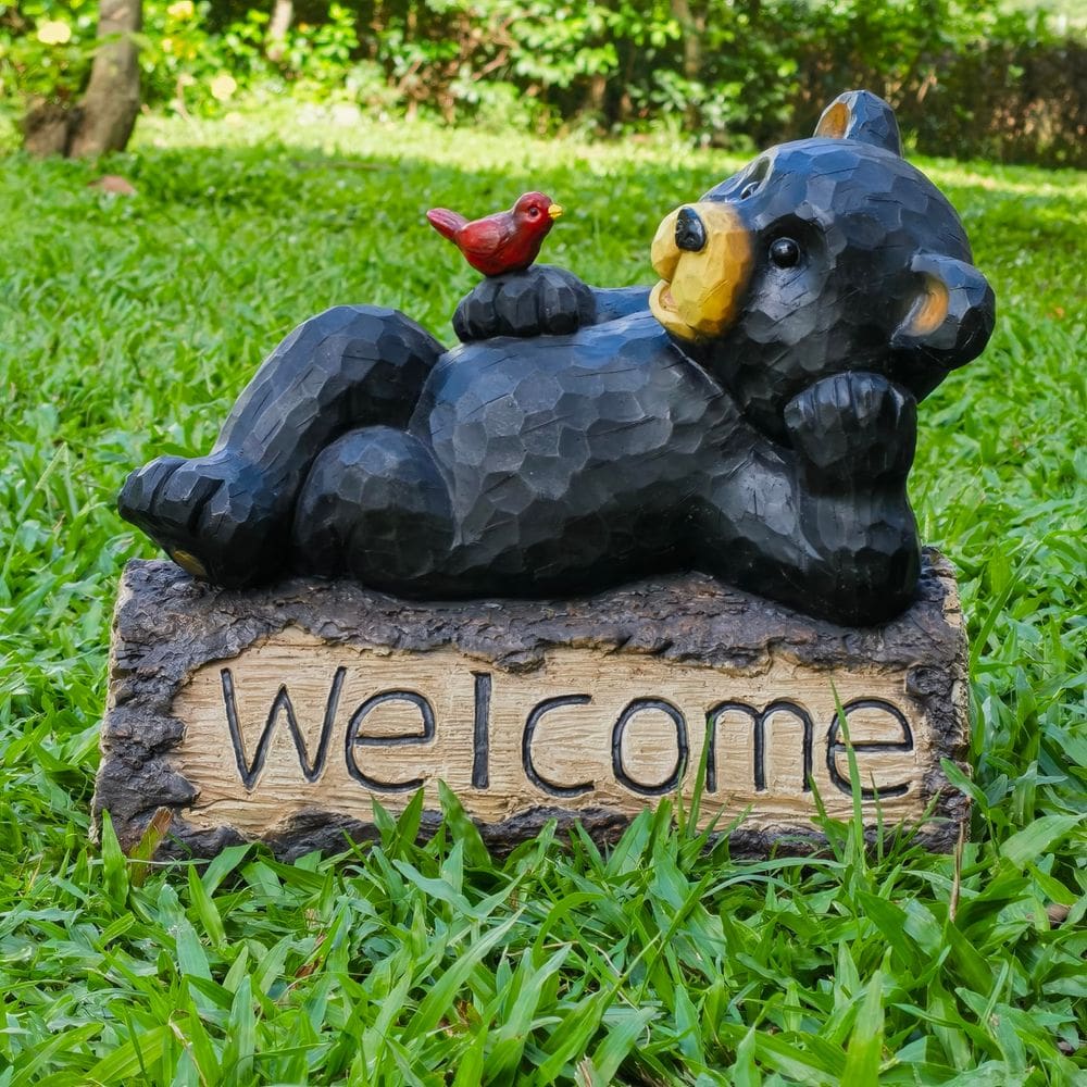 Urso Hi-Line Gift Ltd com placa de boas-vindas cardinal ao ar livre